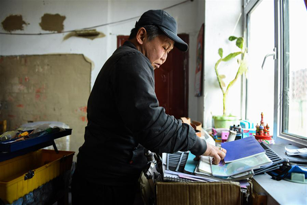        4月15日，在锡尼河镇的出租房内，米格木尔在拿取皮雕工具。新华社记者 刘磊 摄