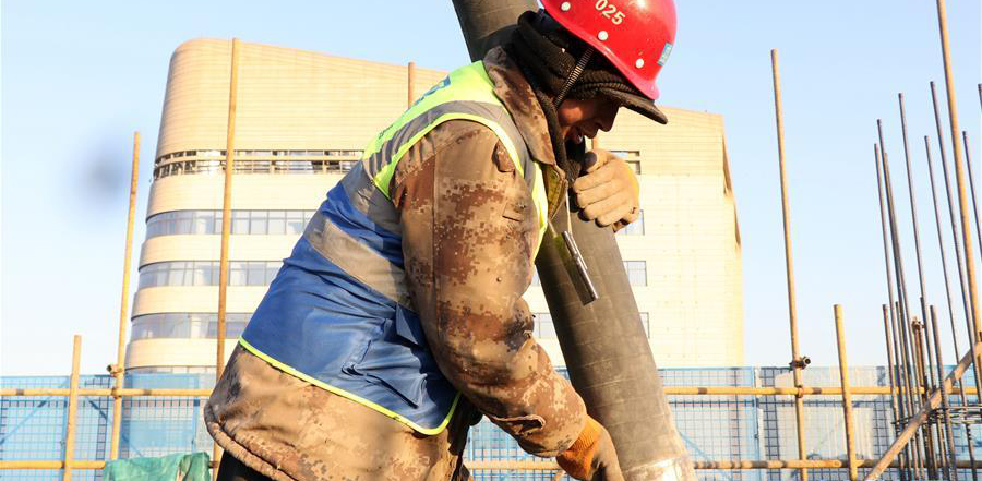 12月16日，在中建三局北京公司北京市大兴区一处项目工地，工人在浇筑水泥。 近日，伴着寒潮到来，多地迎来入冬以来最寒冷天气，一些劳动者在凛冽寒风中依然坚守岗位。